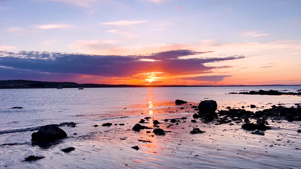 Tranquil Sunset Over Skerries Beach with Boats and Coastal Rocks