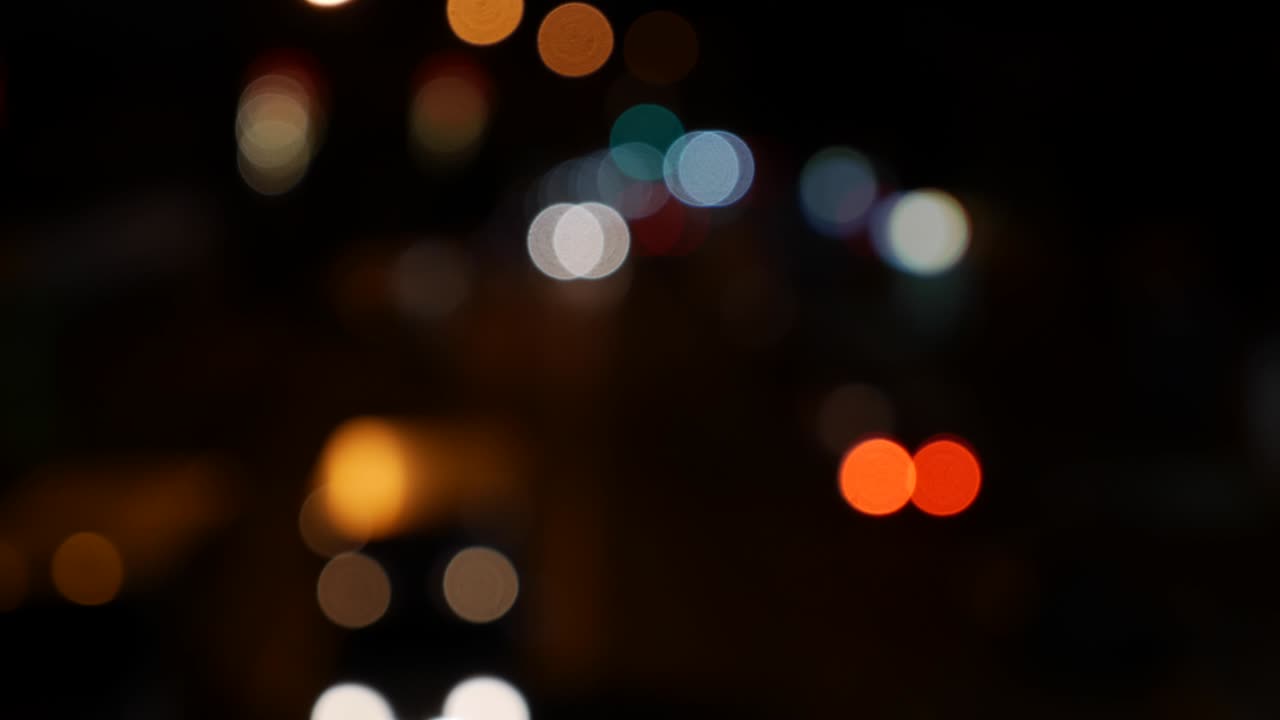 hermoso bokeh brillante en el fondo oscuro borroso por la noche. el redondo bokeh colorido brilla de las luces de los coches en la calle de la ciudad. fuera de foco con borroso. luces de la ciudad sin enfoque. bokeh de tráfico. concepto abstracto