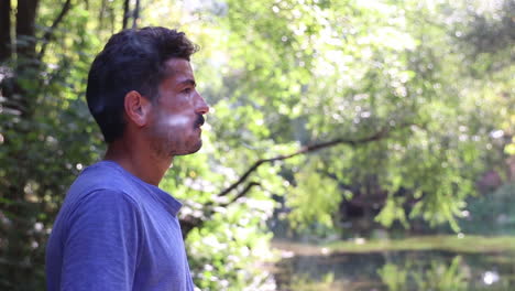 hombre fumando un cigarrillo en el bosque