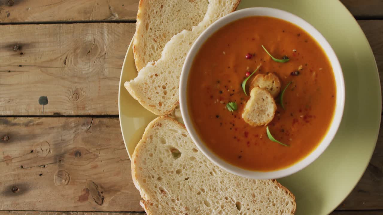 video de sopa de tomate con crema en un tazón en una mesa de madera con pan