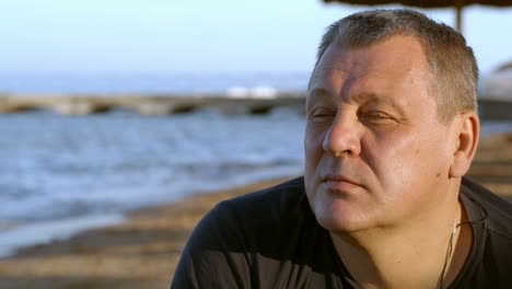 handsome middle-aged man thinking at the beach