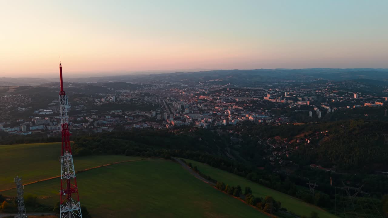 aerial shot over Le Guizay viewpoint with Saint Etienne city in the Background at sunset, Loire departement, Auvergne Rhone Alpes region, France