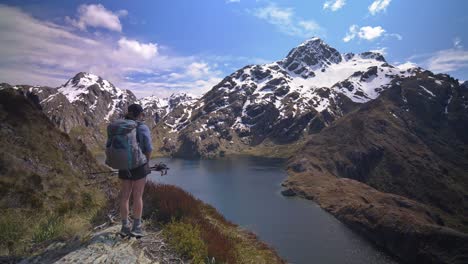 pan, excursionista con vistas al lago alpino en el paisaje de montaña cubierto de nieve, routeburn track nueva zelanda