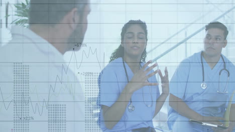 medical team discussing data metrics in hospital hallway with line chart overlay and stethoscopes