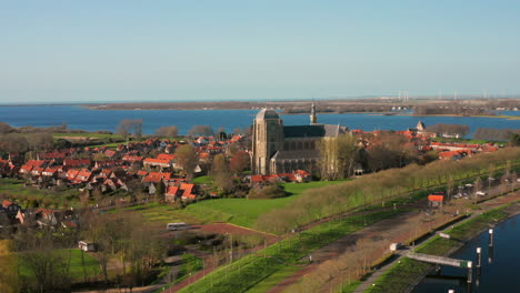 Aerial:-The-historical-town-of-Veere-with-an-old-harbour-and-churches,-on-a-spring-day