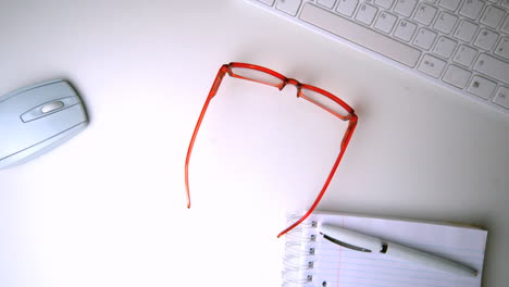 red glasses falling onto office desk