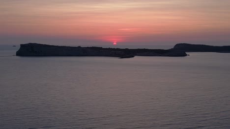 Yoga Hippie Girl at sunset with island in the background, Ibiza, Spain. Gorgeous aerial view flight speed ramp hyper motion time lapse