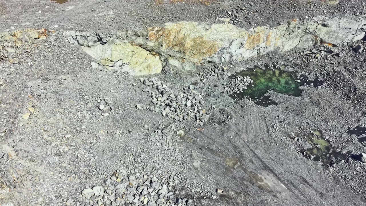 Sito di cava di granito che mostra formazioni rocciose e pozze d'acqua durante le ore diurne