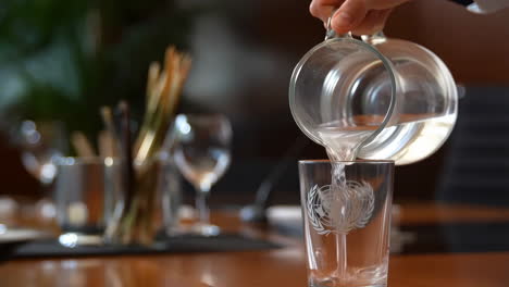 hand pouring water into a glass with the united nations logo