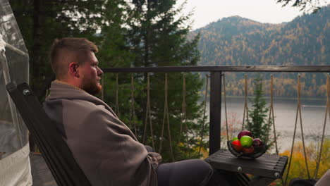 man relaxing on a balcony with a scenic view