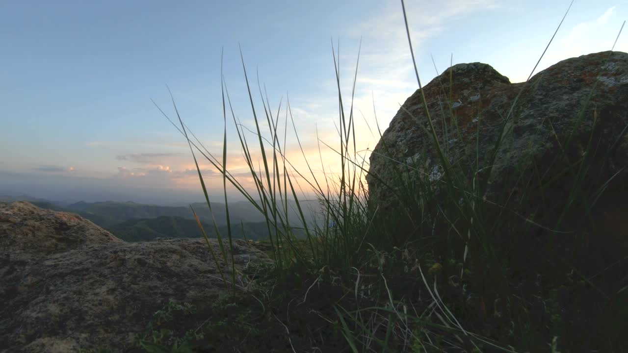 puesta de sol en la montaña sobre la roca pico. clave oscura puesta de sol luz en las montañas paralaje rocas hierba de roca