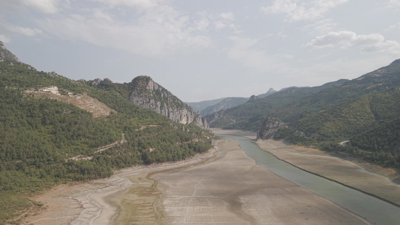 4K 10-bit drone shot flying forward low over a green river inside the giant rocky walls of Sahinkaya Canyon on a sunny day in Samsun, Turkey