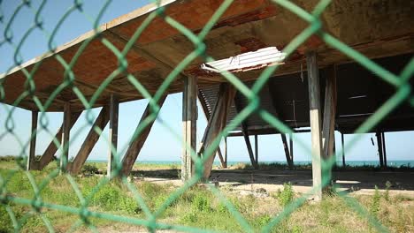 monstruo de hormigón en ruinas gigante en la orilla del mar de detrás de la valla