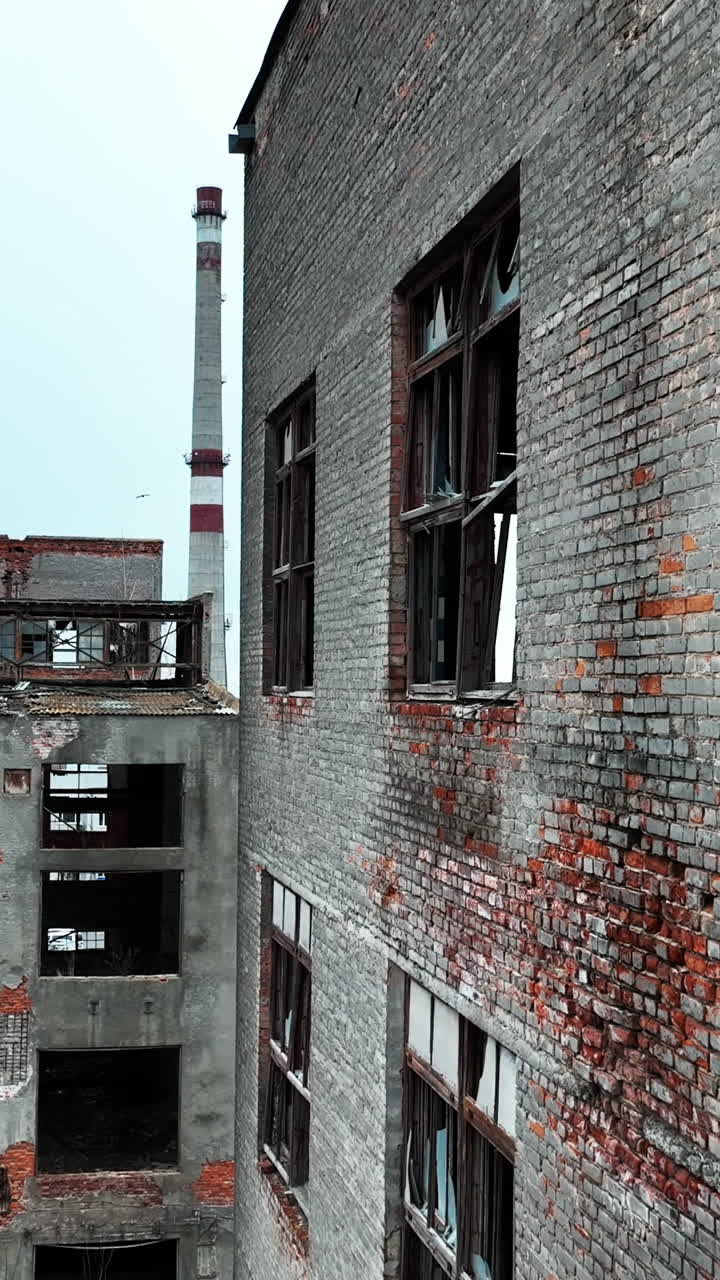 Ruined and abandoned territory of industrial plant. Buildings of an old plant destroyed with time and nature. Vertical video