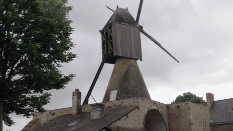 old vintage windmill in french country side on field under cloudy sky