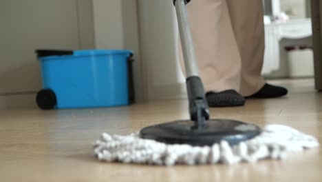 person mopping a wooden floor