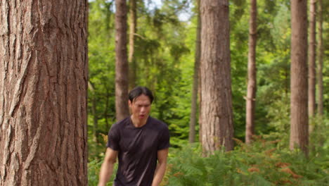 tired mid adult man exercising doing work out outdoors running along track through forest stopping to catch breath shot in real time 2