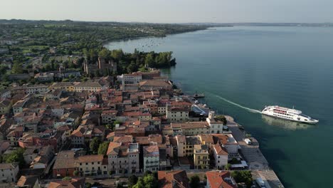 aerial footage of ferry pulling away from the pier at a charming sea-side town in italy