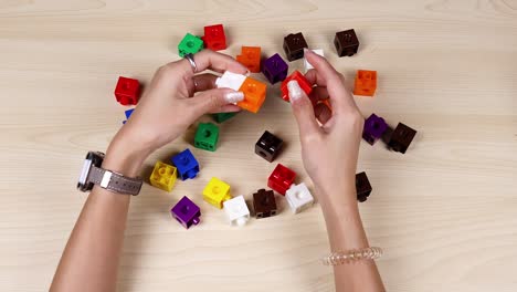 hands organizing colorful cubes on a table