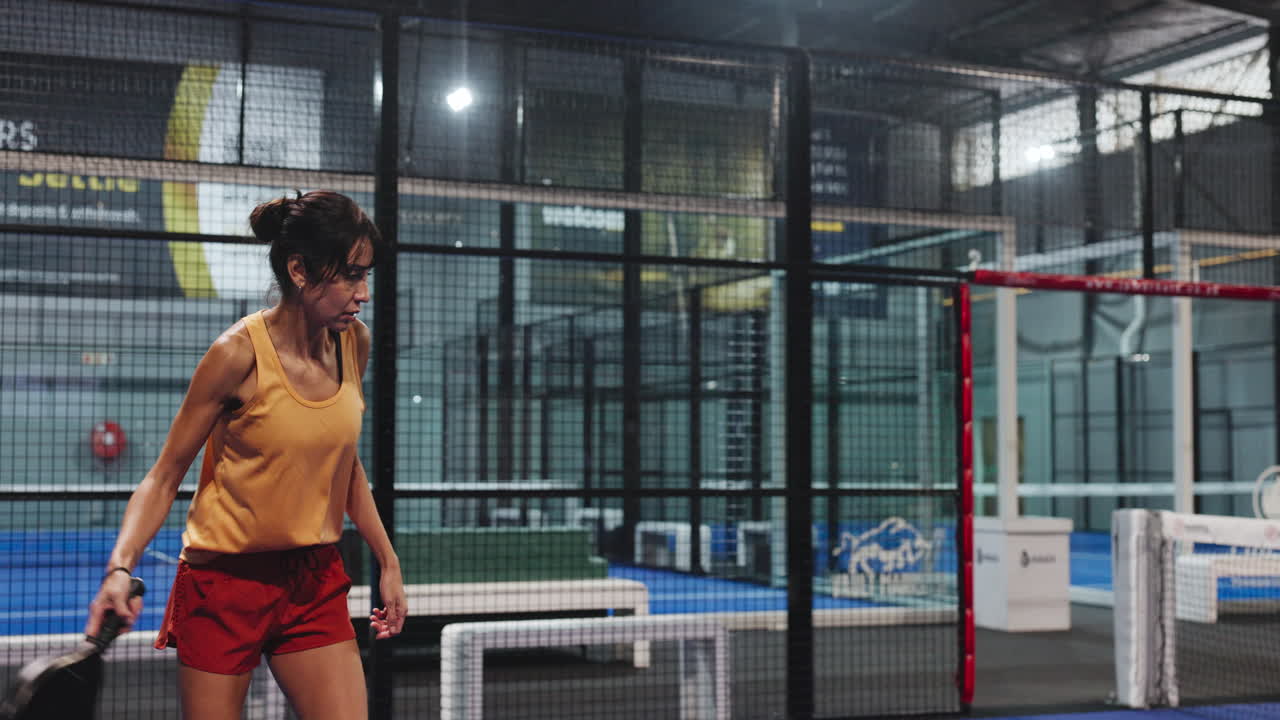 Frau spielt drinnen Padel-Tennis