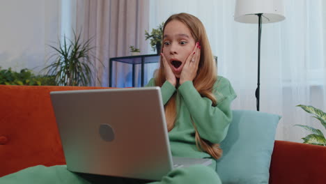 amazed child girl use laptop computer, receive good news message, shocked by victory, celebrate win