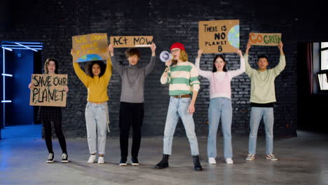 junge umweltaktivisten mit plakaten und megafon, die gegen die untätigkeit des klimawandels protestieren