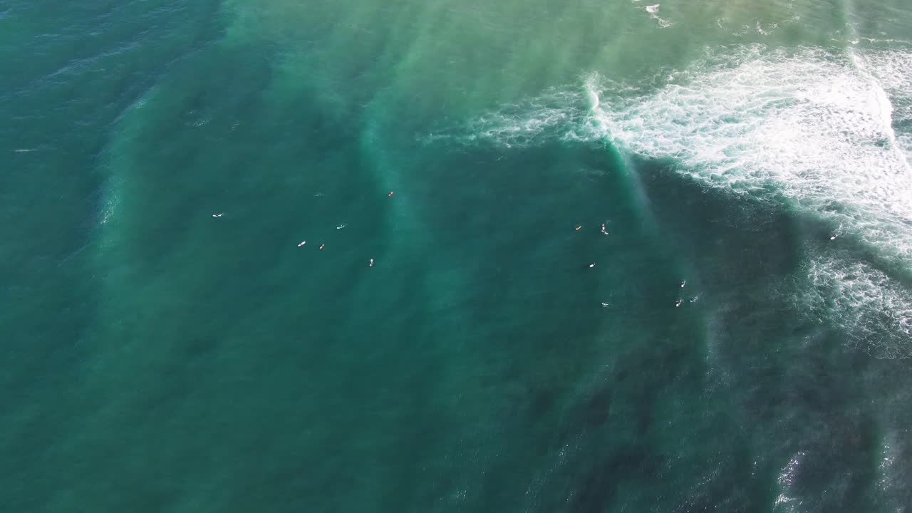 Vista aérea do pico de surf de Parlamentia, País Basco Francês, com linhas de ondulação e surfistas pegando ondas do line-up e as surfando até a costa