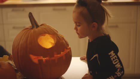 girl blowing at jack o lantern