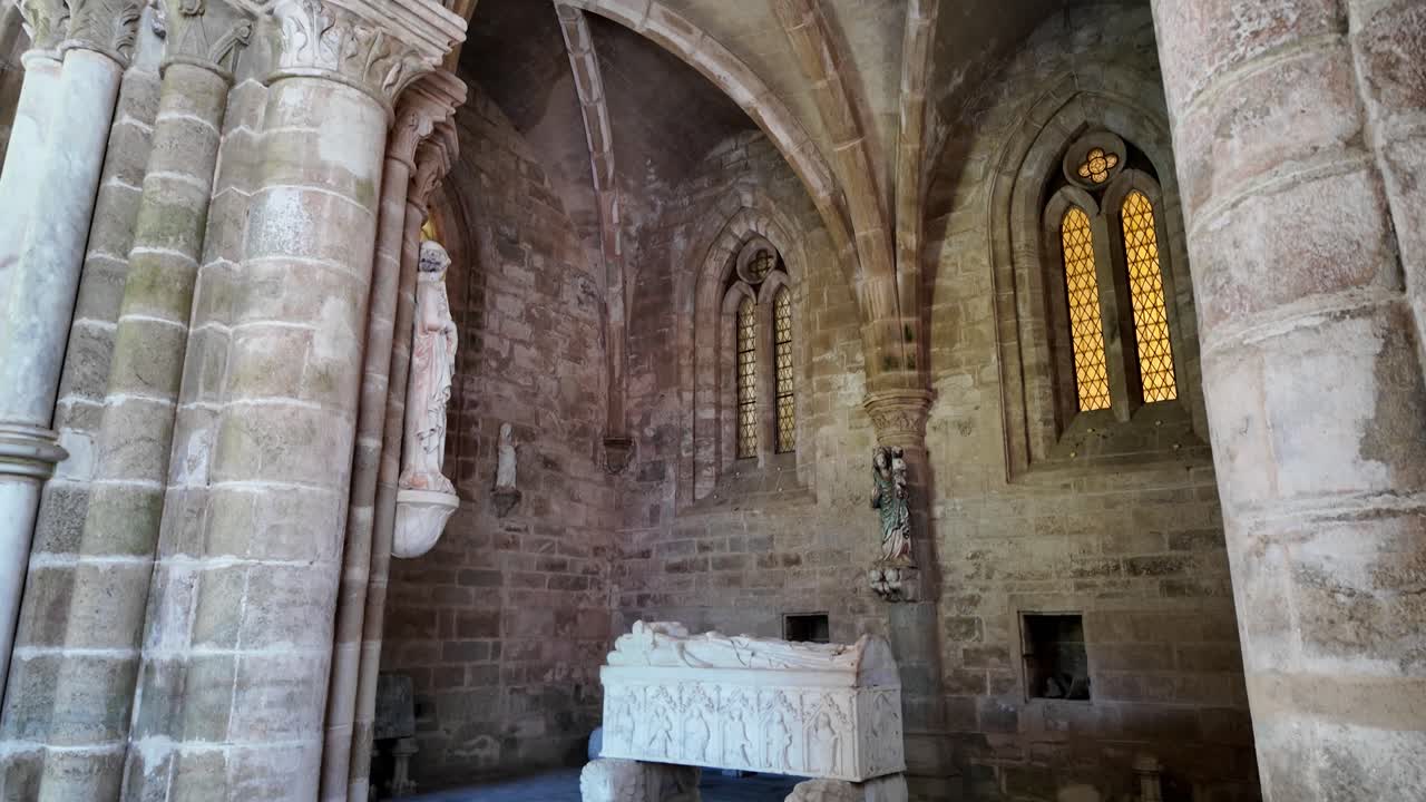 A serene interior shot of the Cathedral of Évora cloister, featuring intricate architecture, statues, and stained glass windows