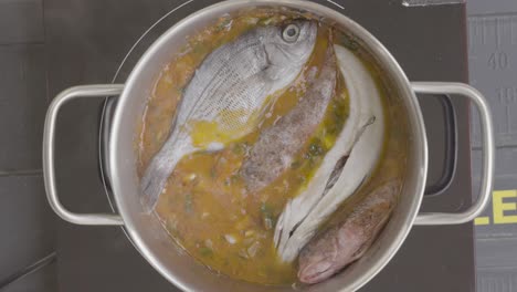 el cocinero prepara el almuerzo, pone el pescado listo para cocinar