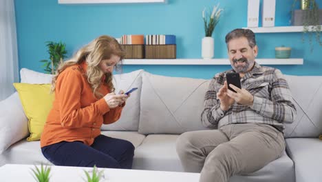 The-couple-using-the-phone-do-not-talk-to-each-other.-Communication-problem-at-home.