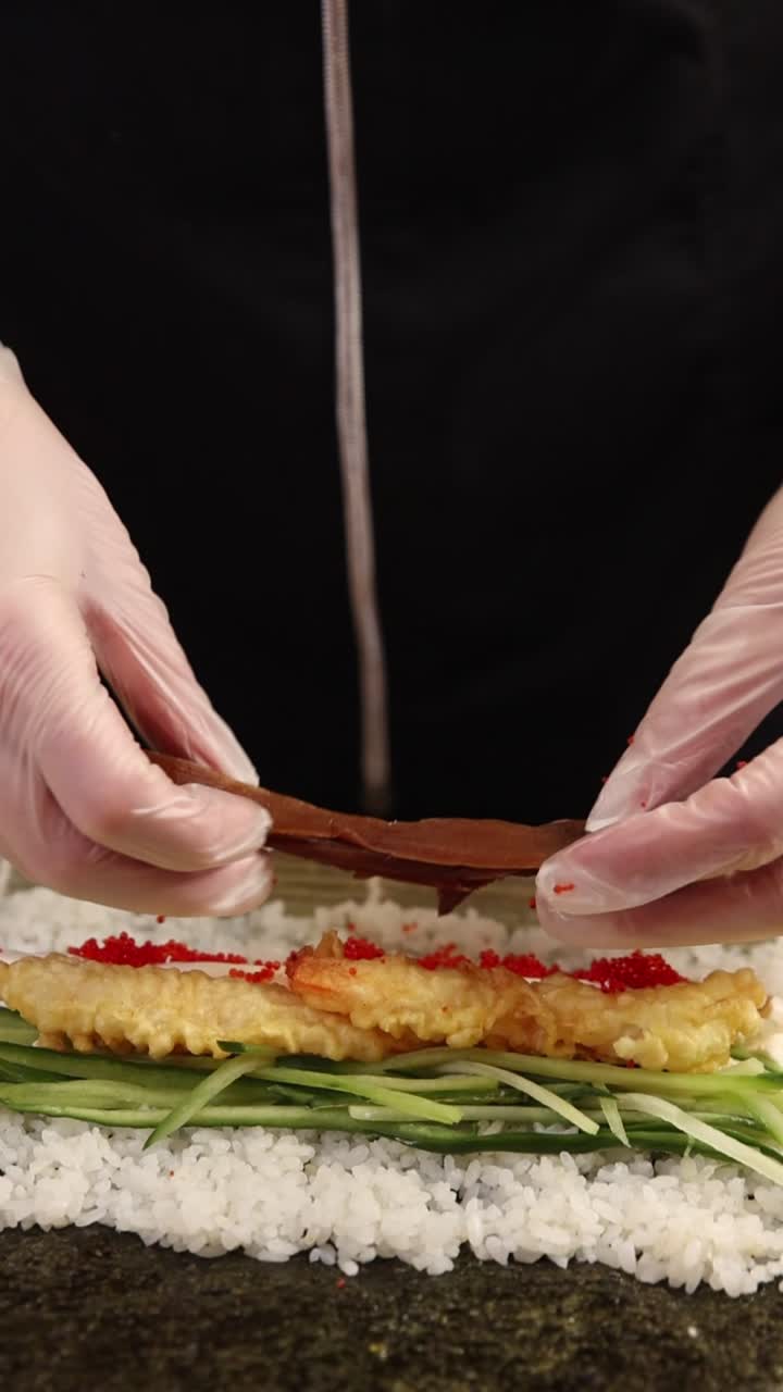 Chef's Hands Preparing Sushi Roll with Tempura Shrimp and Ingredients