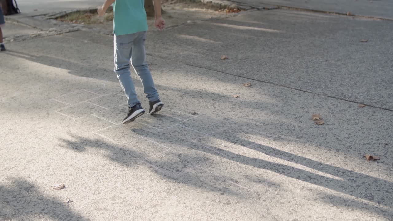 공원에서 친구들과 돌차기 놀이를 하는 소년