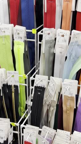many different zippers for clothes of different sizes and colors zippers on racks in the workshop many different zippers for clothes in different sizes and colors lightnings are placed on racks in the workshop of a clothing atelier