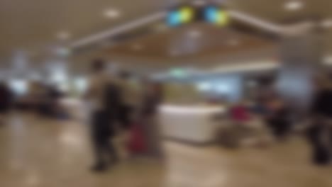 An-unfocused-hyperlapse-walking-in-an-airport,-with-people-walking-around