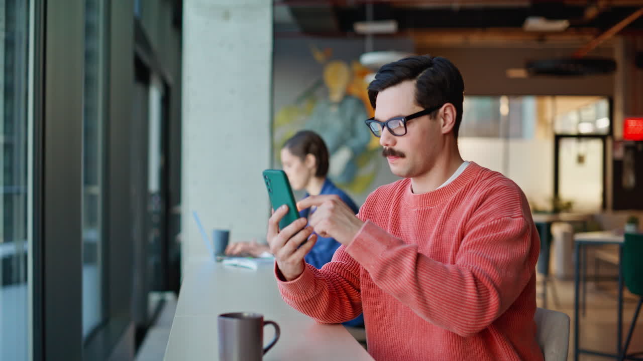 Man scrolling cellphone cafeteria closeup. Guy choosing purchases smartphone