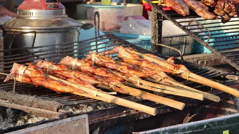 skewered prawns being grilled over charcoal flames