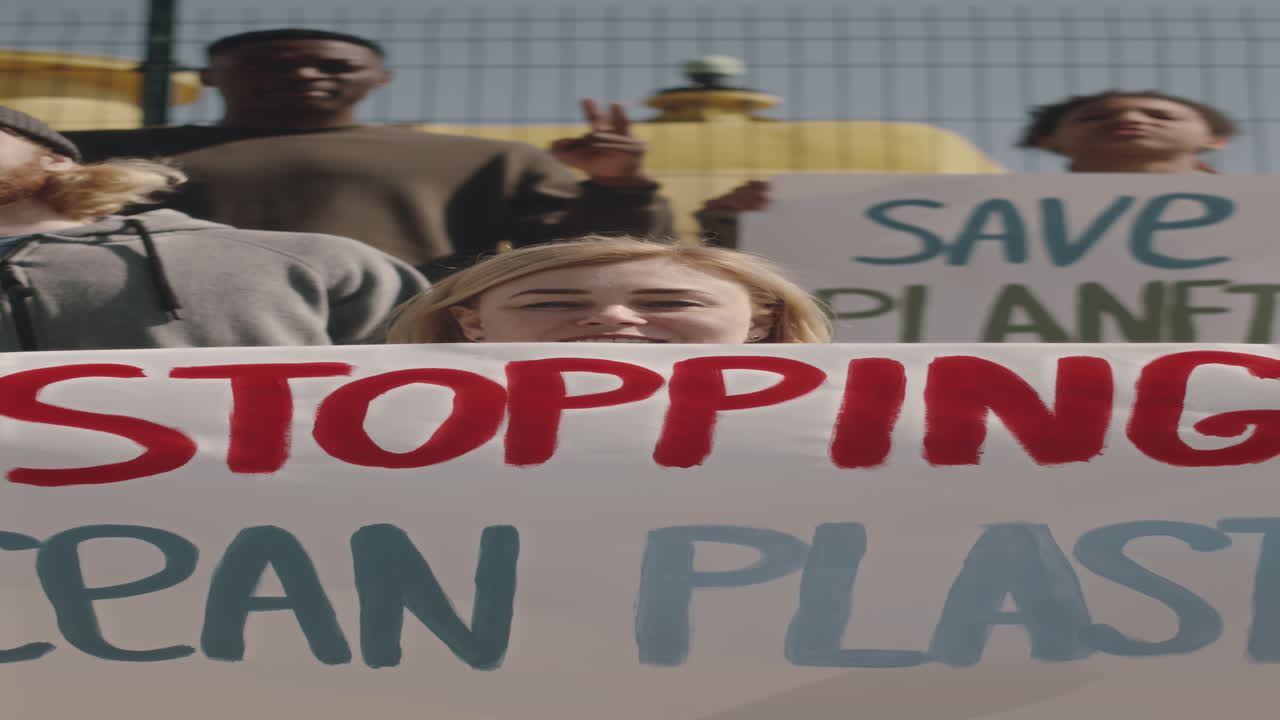 Environmental Activist Holding Poster and Chanting Slogan on Camera
