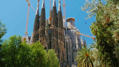 Más-Cerca-De-La-Sagrada-Familia,-Un-Video-Dinámico-Con-Movimiento-De-Cámara,-El-Parque-Está-Cerca-De-Los-Turistas-Que-Caminan