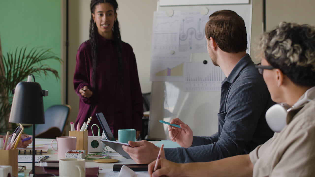 Team of Professionals Collaborating and Presenting in an Office Meeting