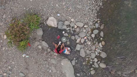 Filipino-Woman-Washing-Dishes-in-Shallow-River