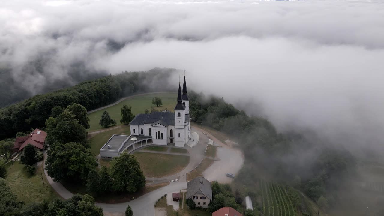 안개 속의 언덕 꼭대기에 있는 교회의 아름다운 전망