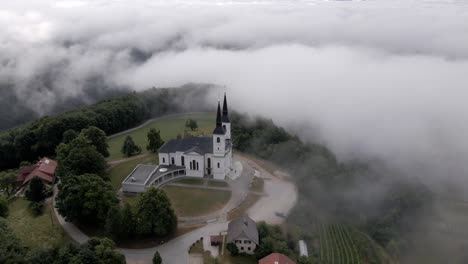 hermosa vista de la iglesia en la cima de la colina en la niebla