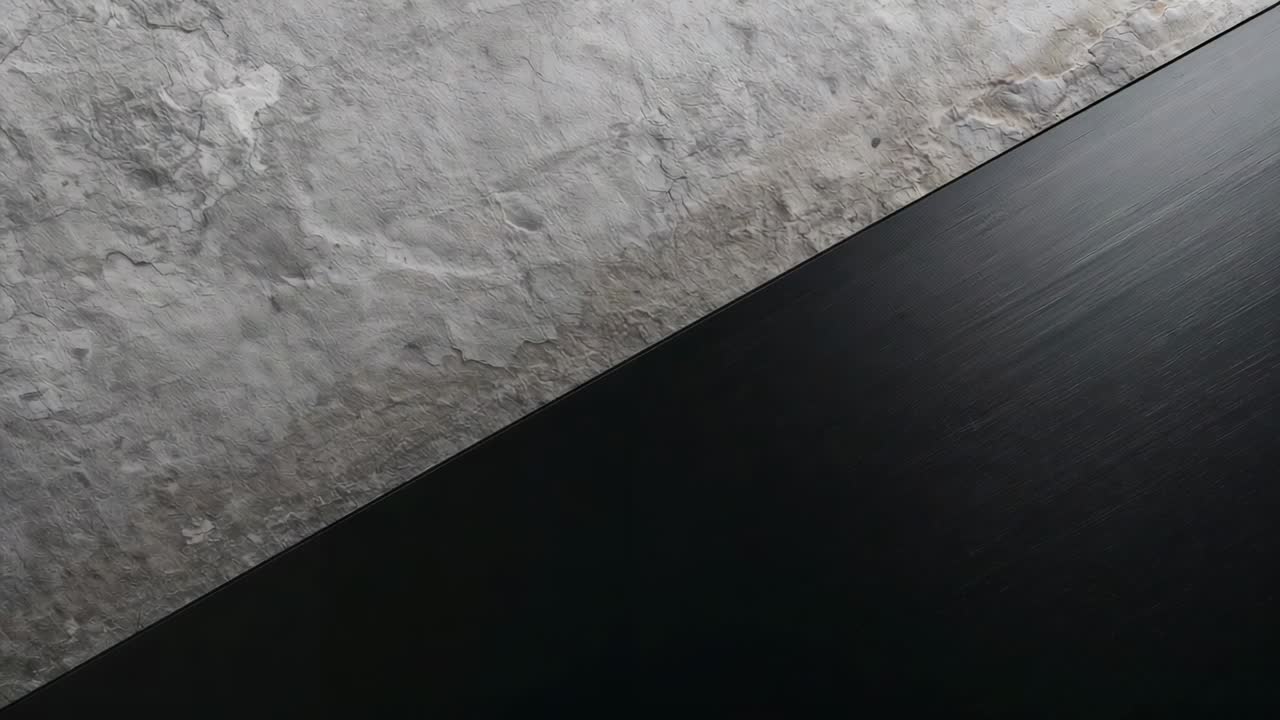 Shifting camera capturing dark flat panel sliding diagonally along plaster wall, moving highlight