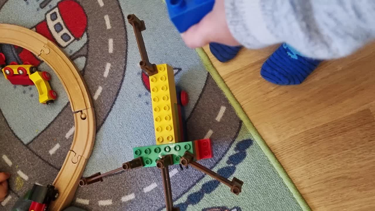 Toddler Playing with Lego Blocks and Wooden Train