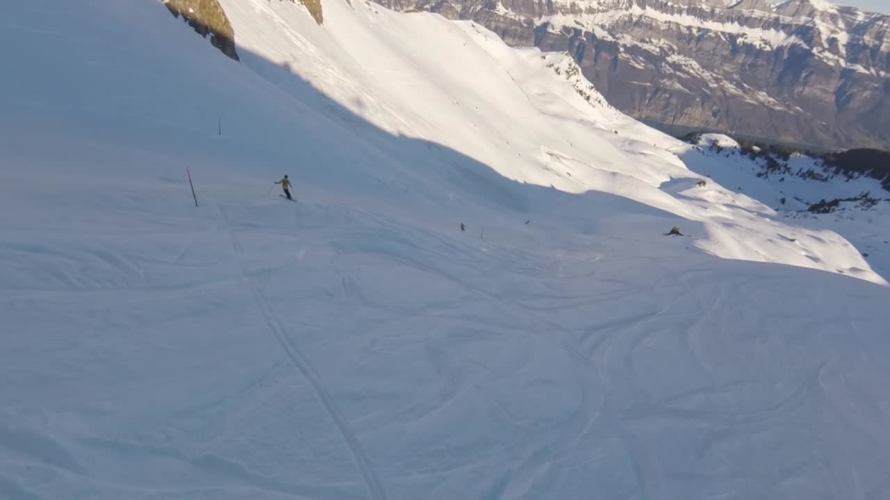 vuelo fpv aéreo de alta velocidad por una pista de esquí en la montaña suiza nevada, carrera
