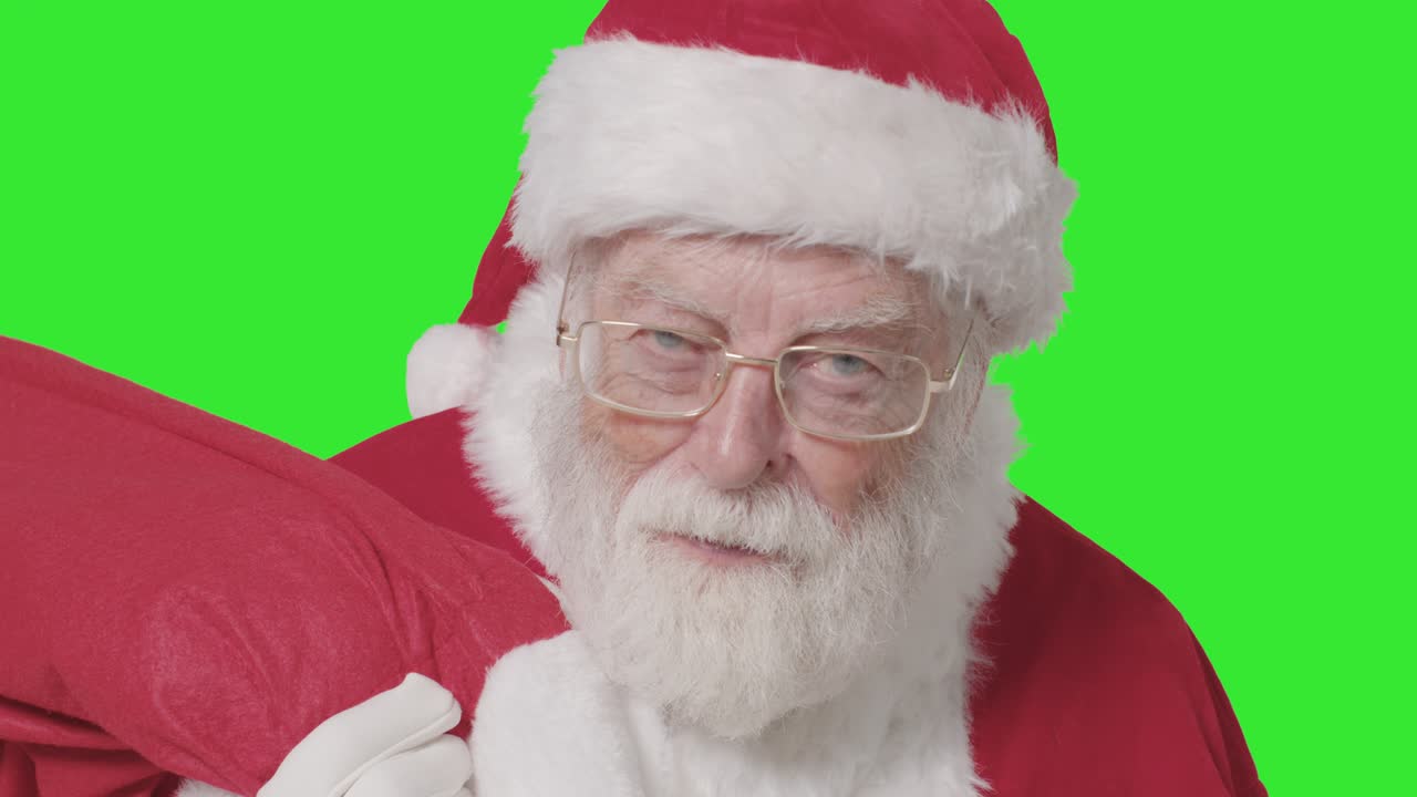 녹색 화면으로 자루를 들고 프레임 안팎으로 걷는 산타의 클로즈업 샷