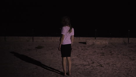 Woman-lit-by-light-at-night-in-Mallorca,-Spain