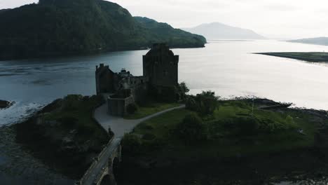 drone shot of a castle's silhouette in scotland's brooding countryside