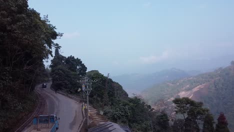 aerial shot of north bengal hill station, slow pan shot of cars and trucks passing on road and mountains